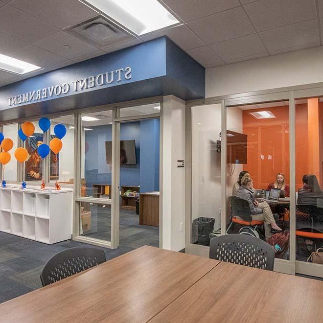 View outside Student Government space with students meeting in room alongside